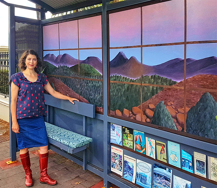 Artist Bridgette Minuzzo with a recent bus shelter intervention. Bringing nature-connection to a busy city roadway, a commission for the City of Prospect. Photo by Louis Potter.